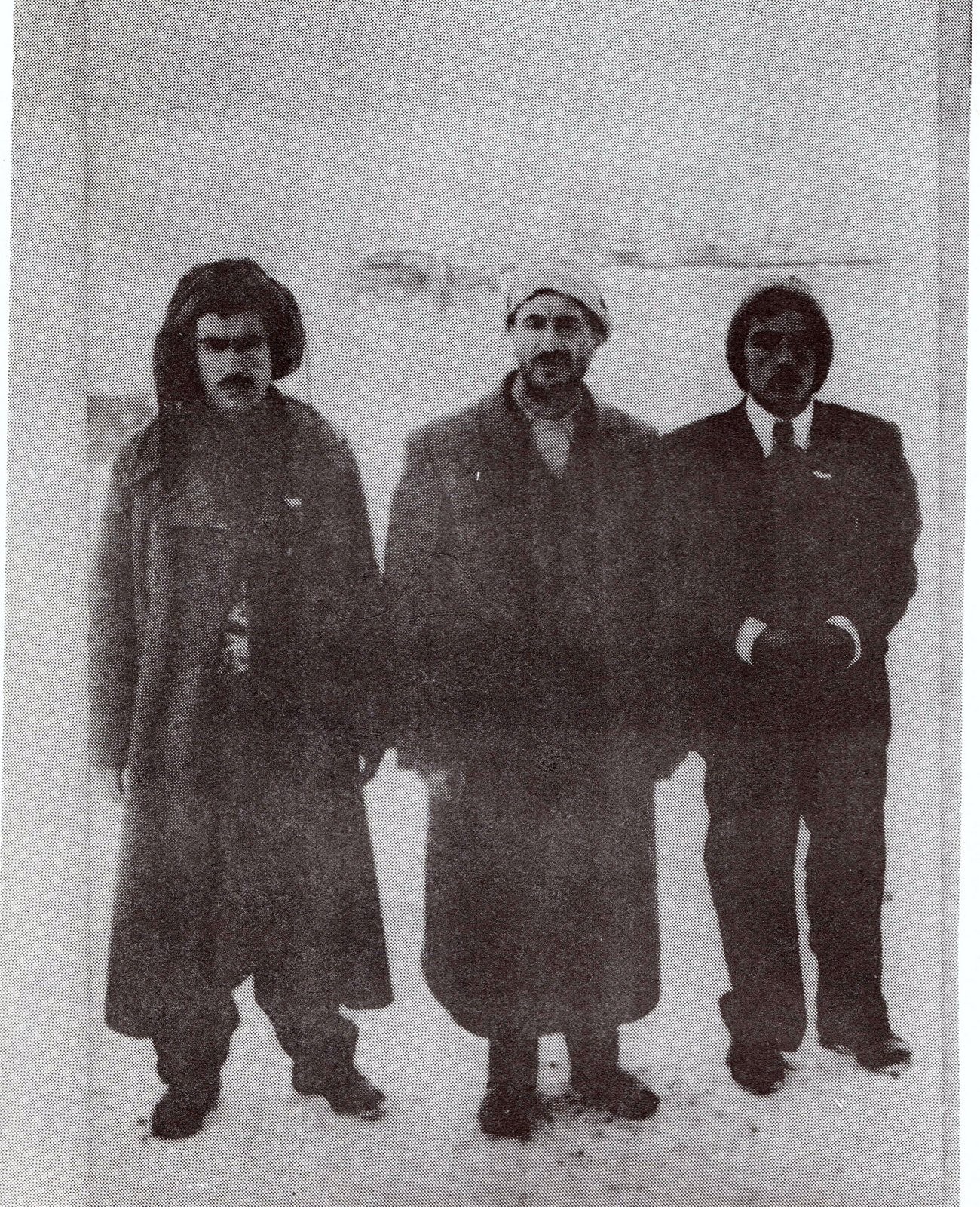 three men in winter coats