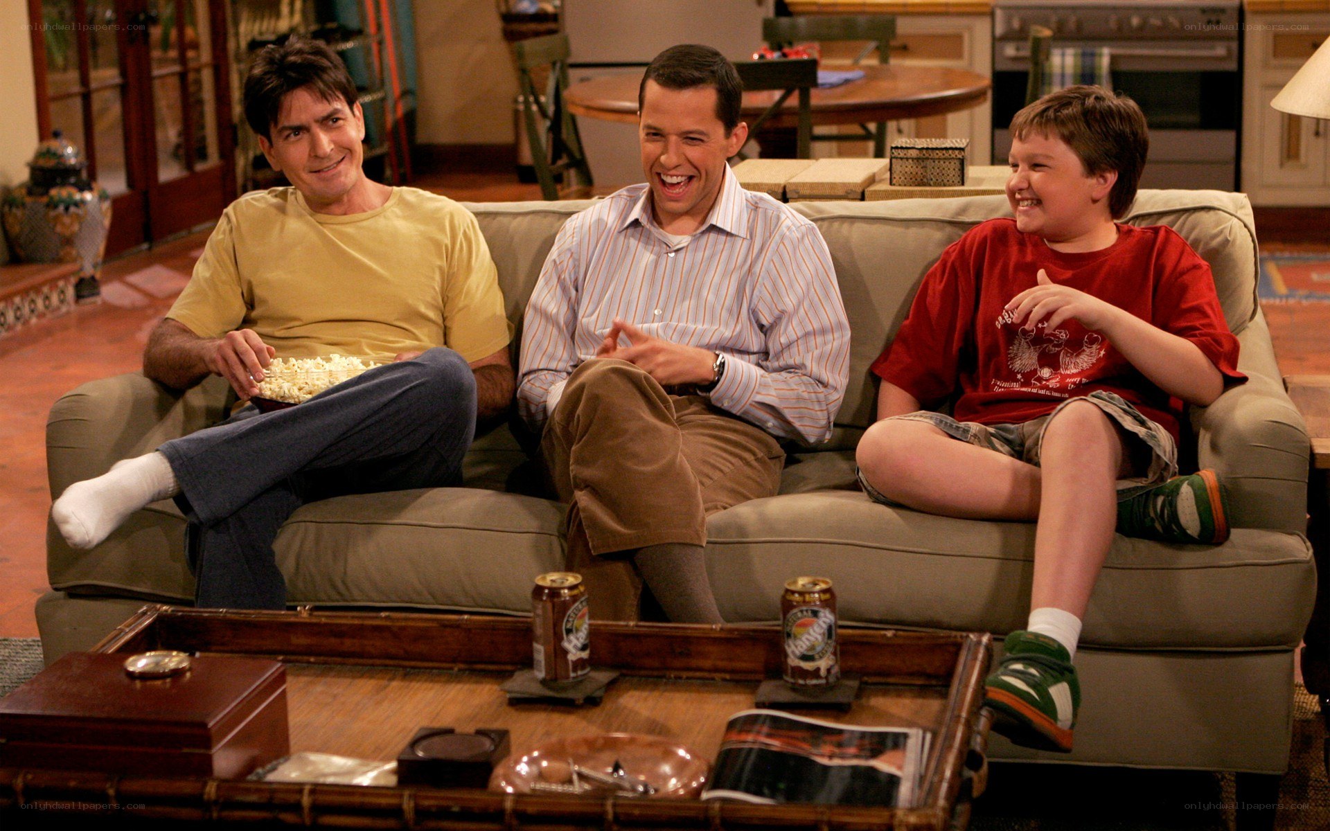 Three men laughing on a couch