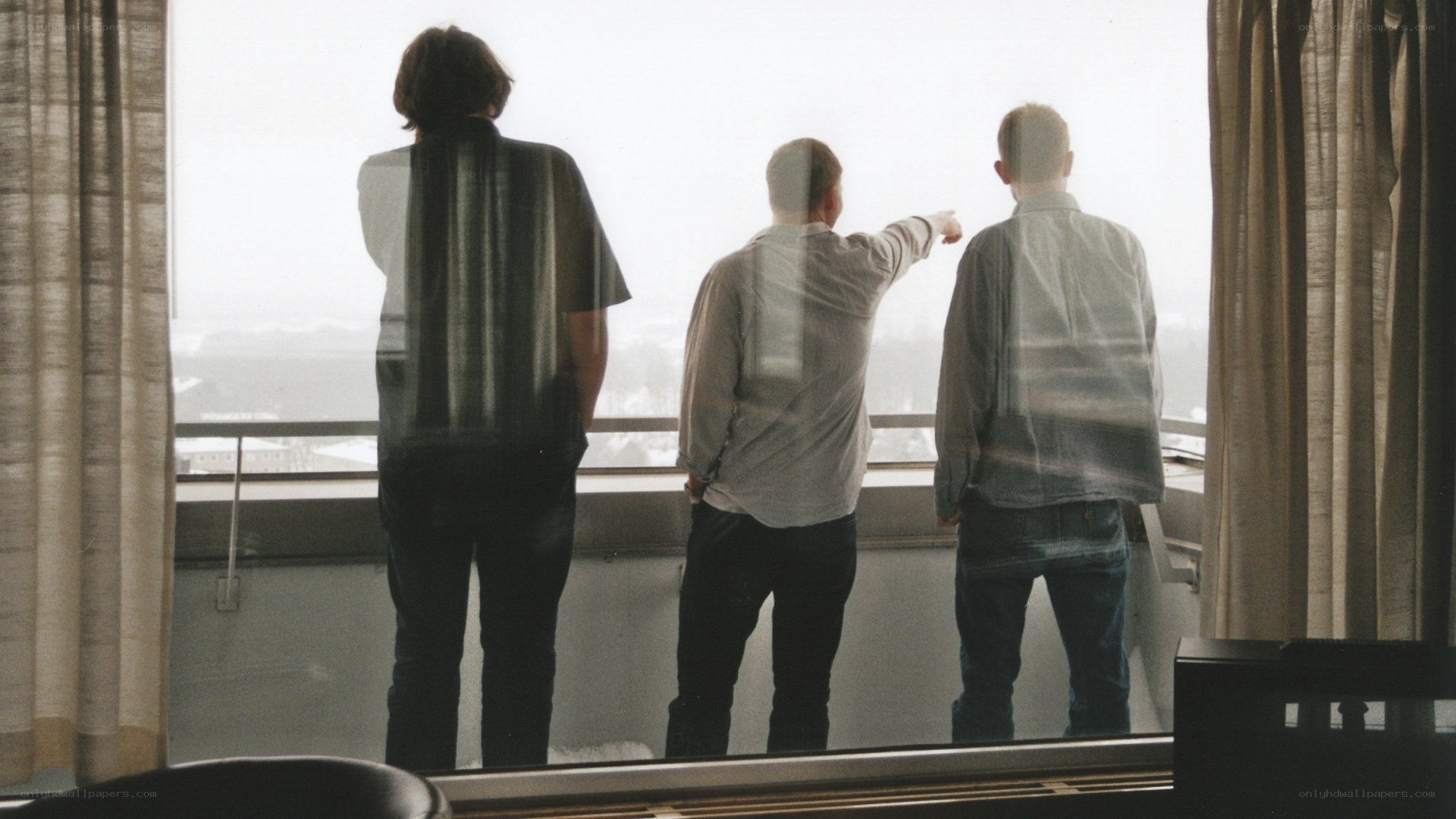 Three men looking out a window