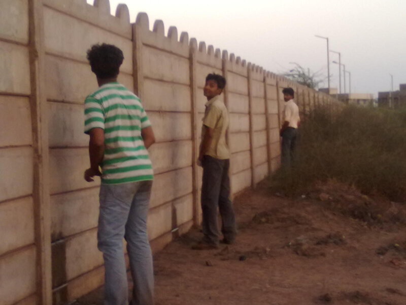 Three men near a wall