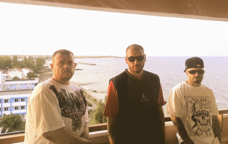 Three men on a balcony overlooking the sea
