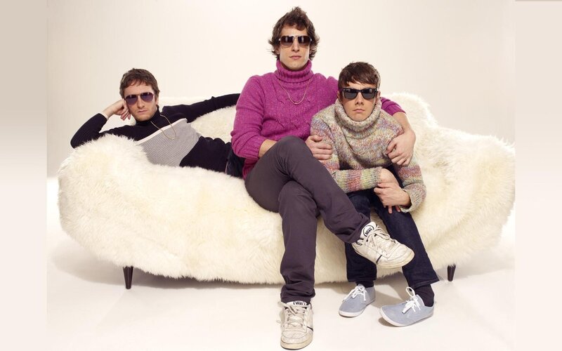 three men on a white couch