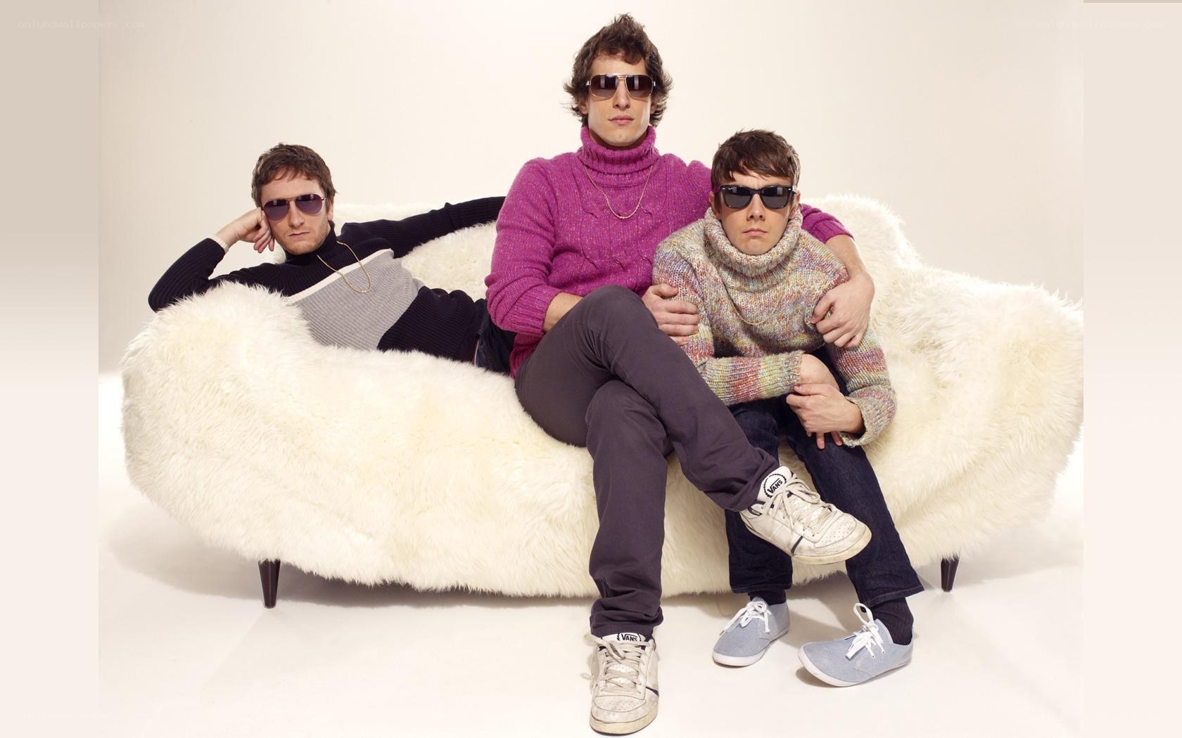 three men on a white couch