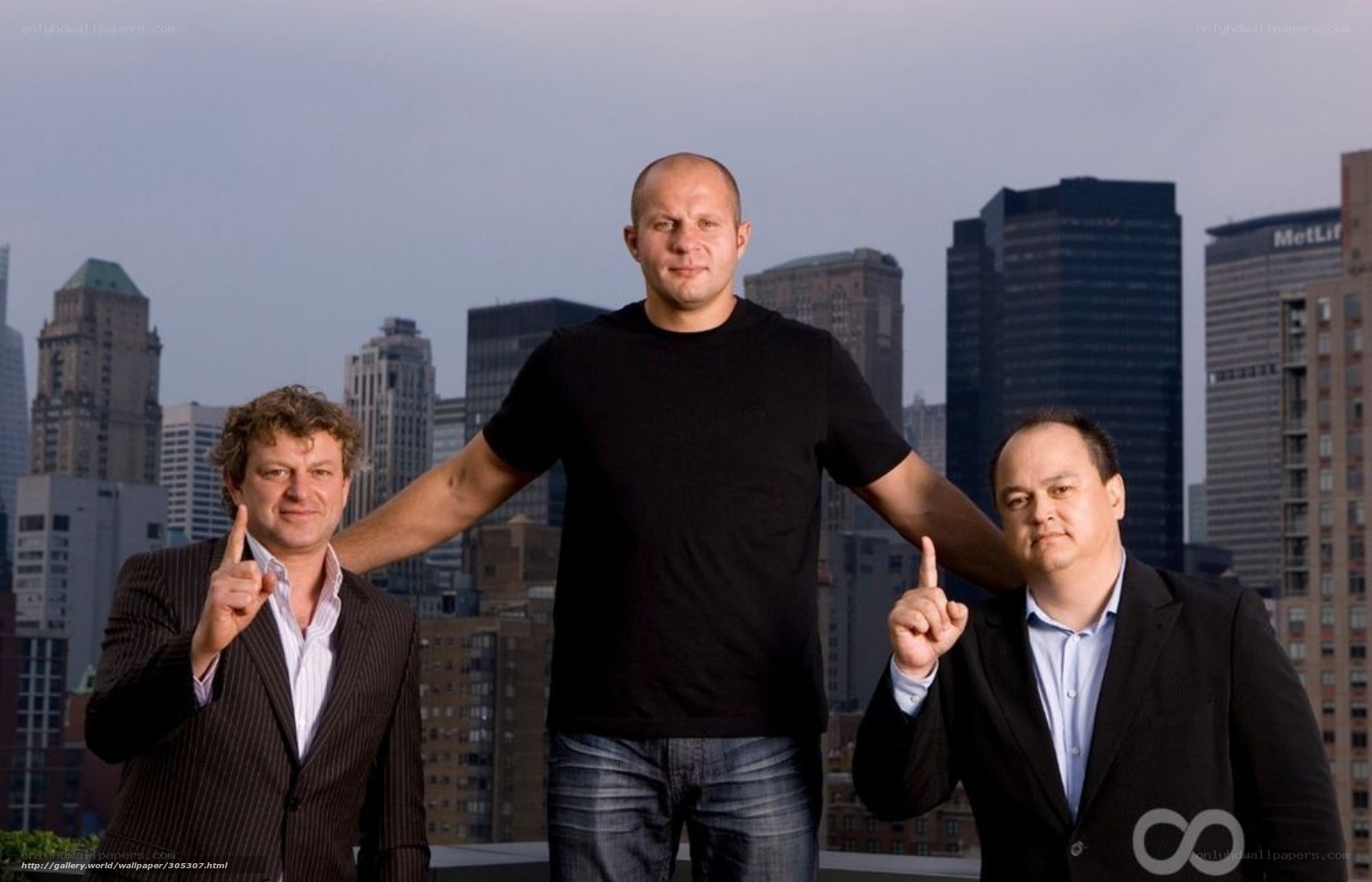 three men on rooftop with city view