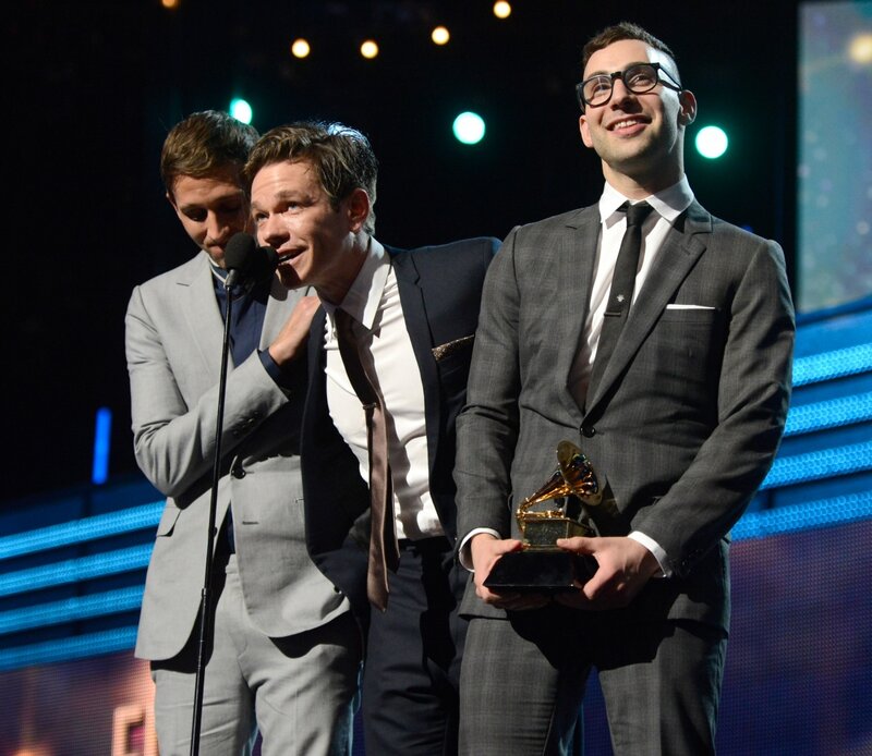 Three Men on Stage — Black, Celebratory
