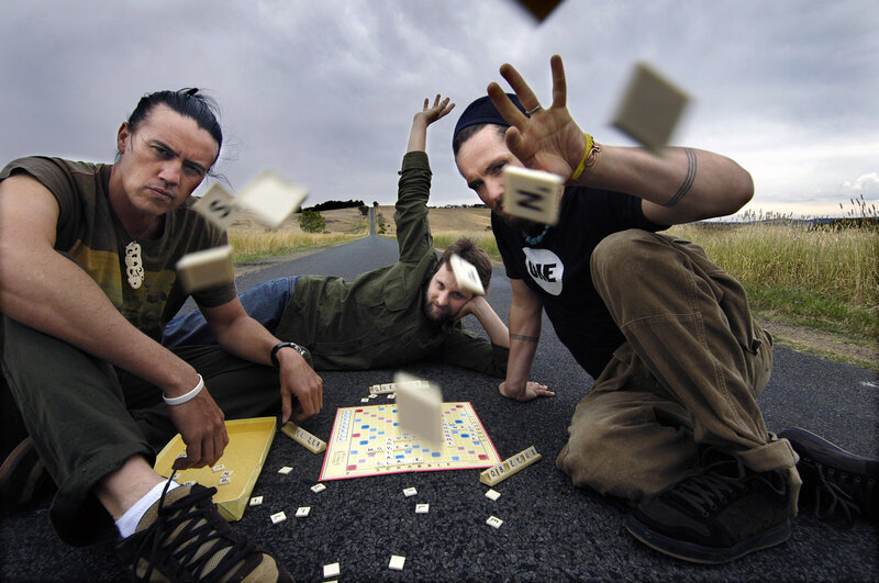 Three men playing Scrabble on a road