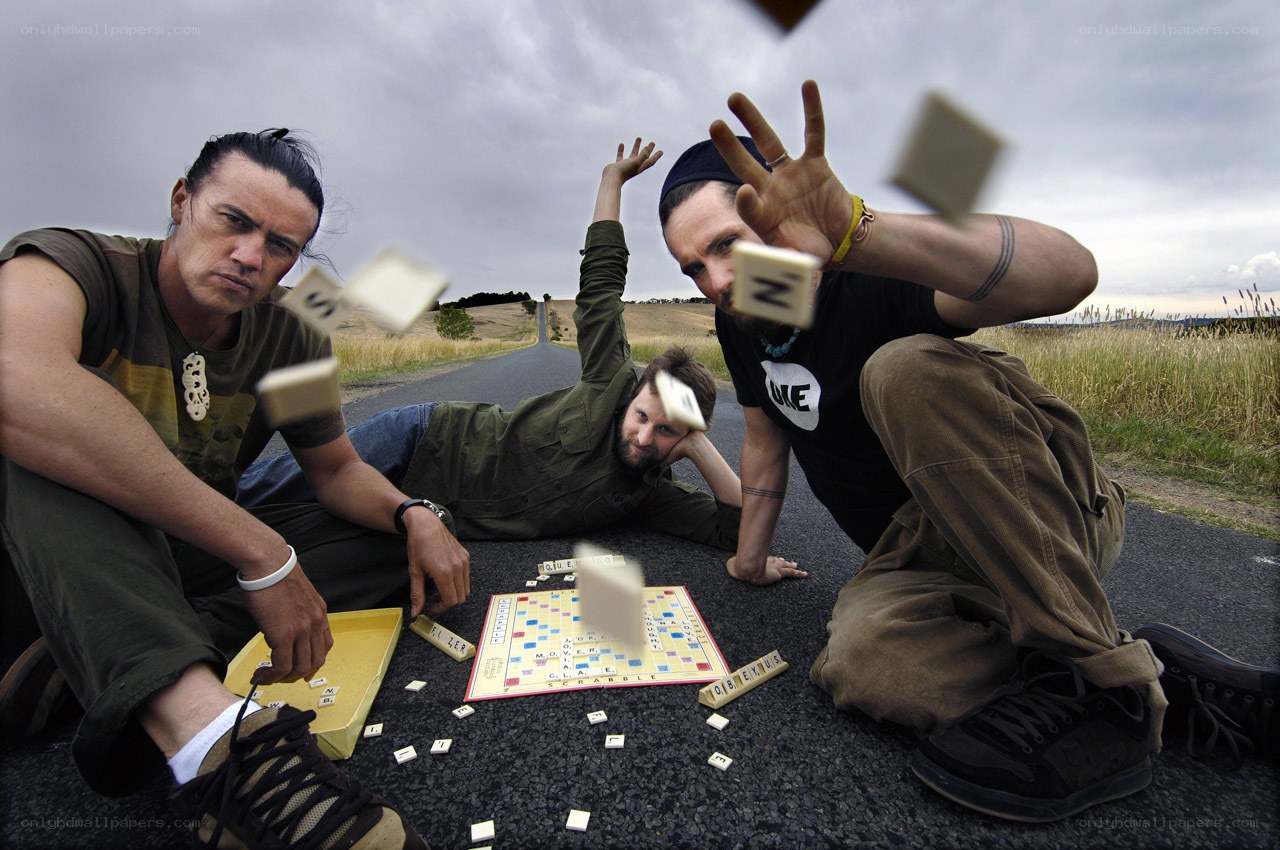 Three men playing Scrabble on a road