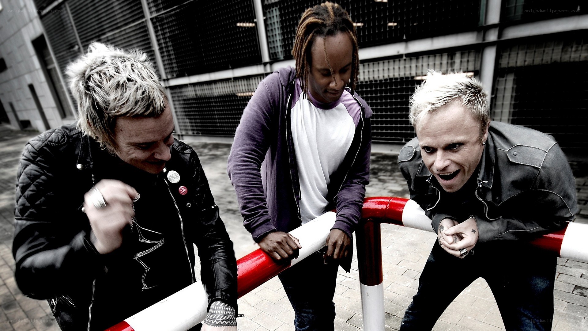 three men posing by a railing