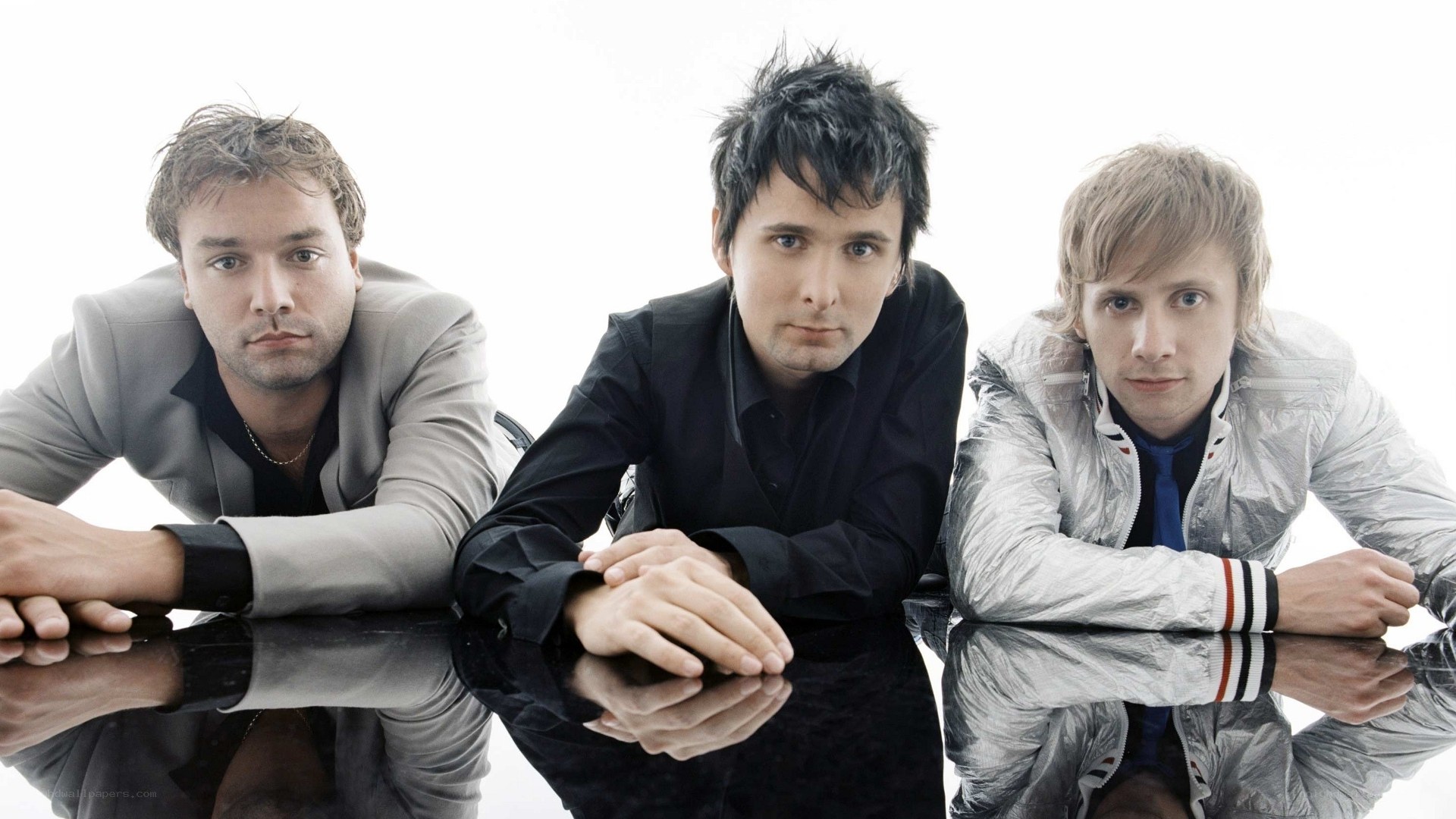 three men posing on reflective surface
