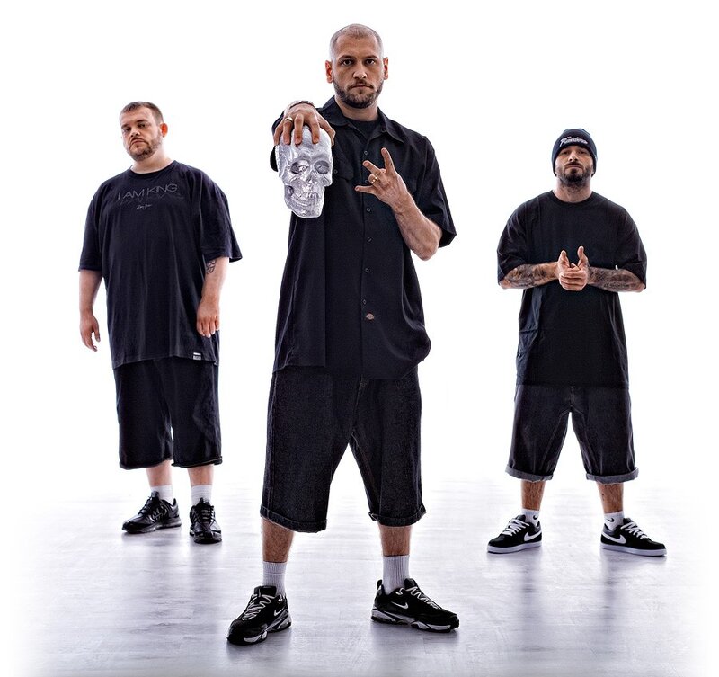 Three men posing with a skull