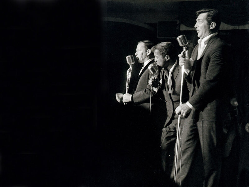 Three men singing on stage