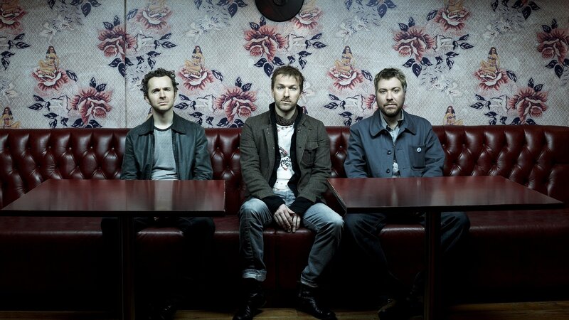 three men sitting in a booth