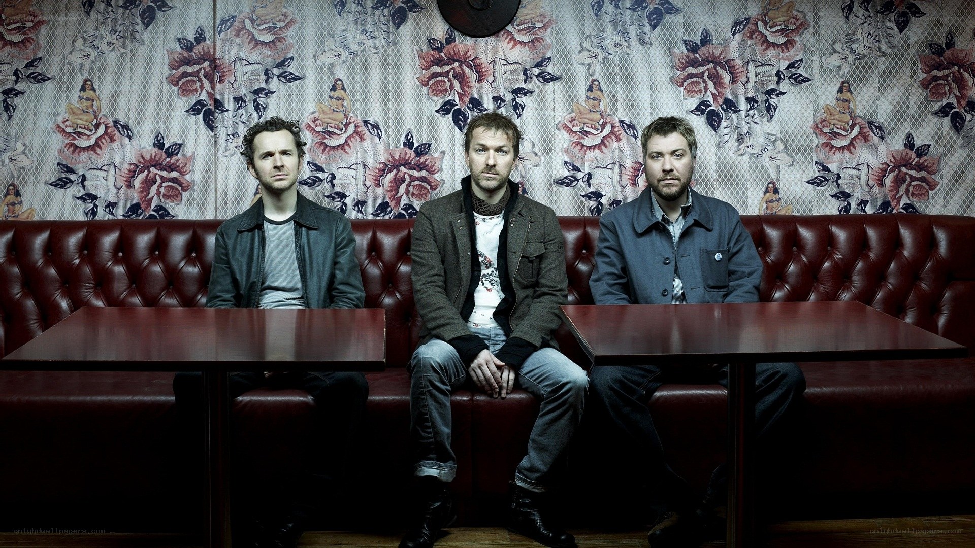 three men sitting in a booth