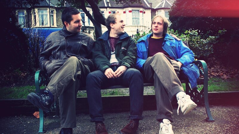 three men sitting on a bench