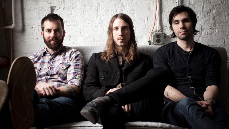 three men sitting on a couch
