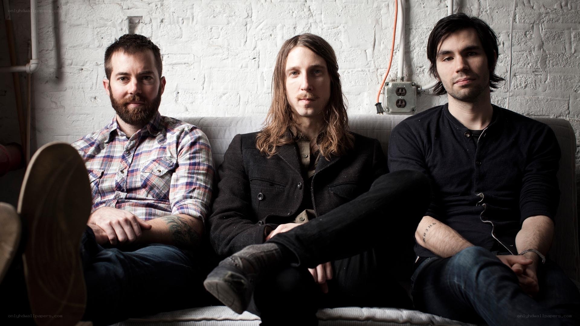 three men sitting on a couch