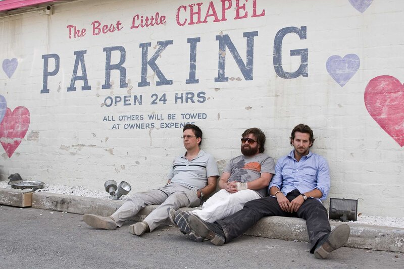 Three men sitting on a curb