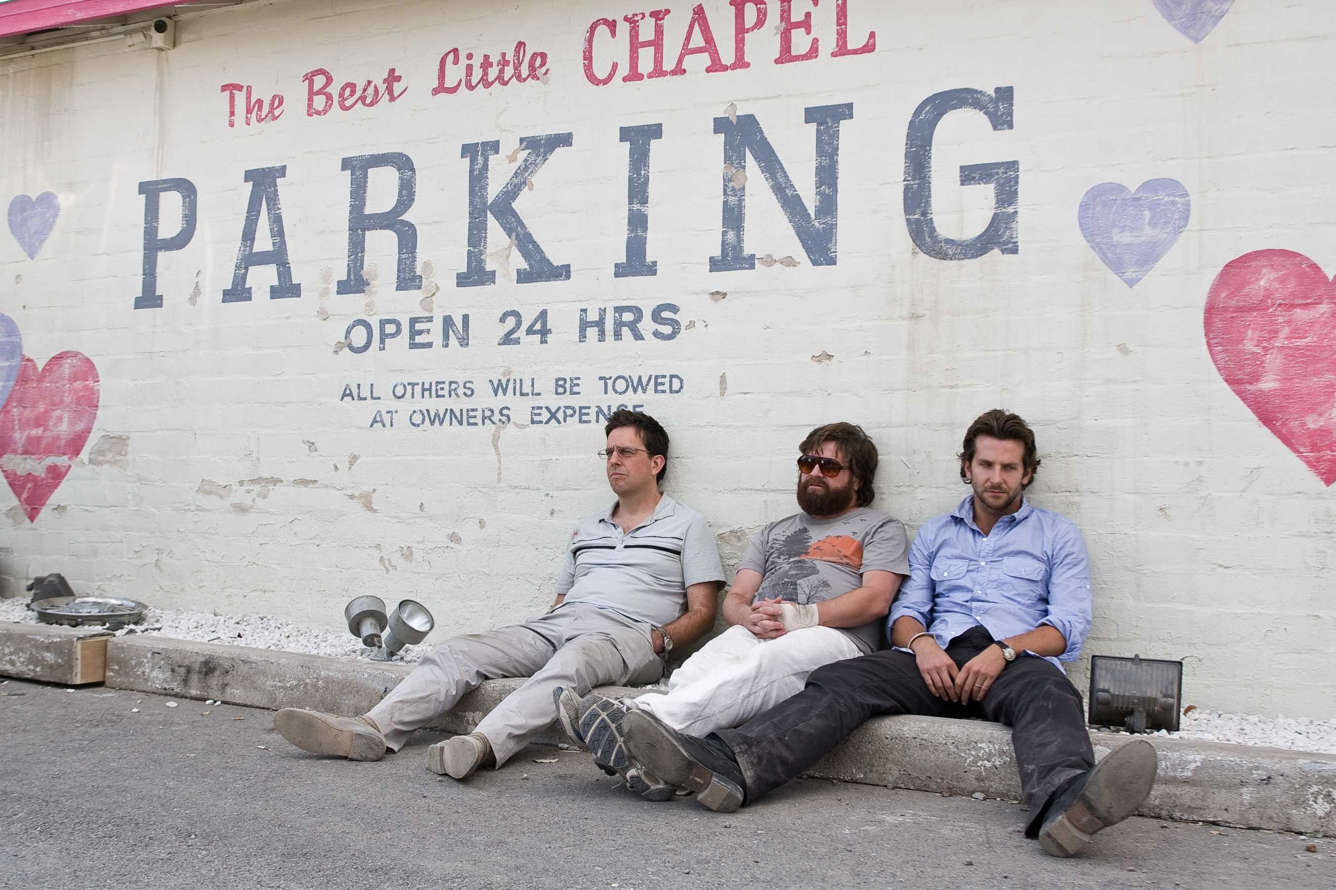 Three men sitting on a curb