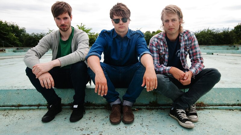 three men sitting on a ledge