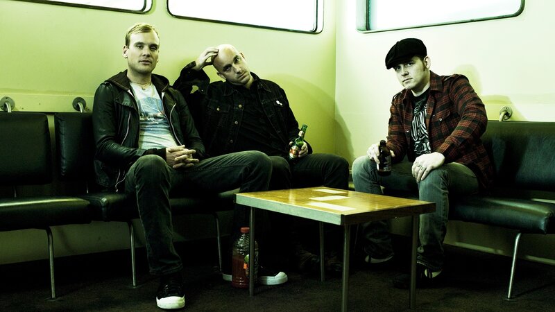 three men sitting on a train