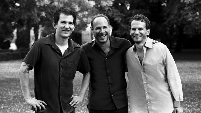 three men smiling in park