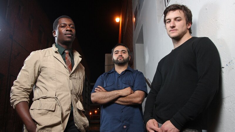three men standing in alley