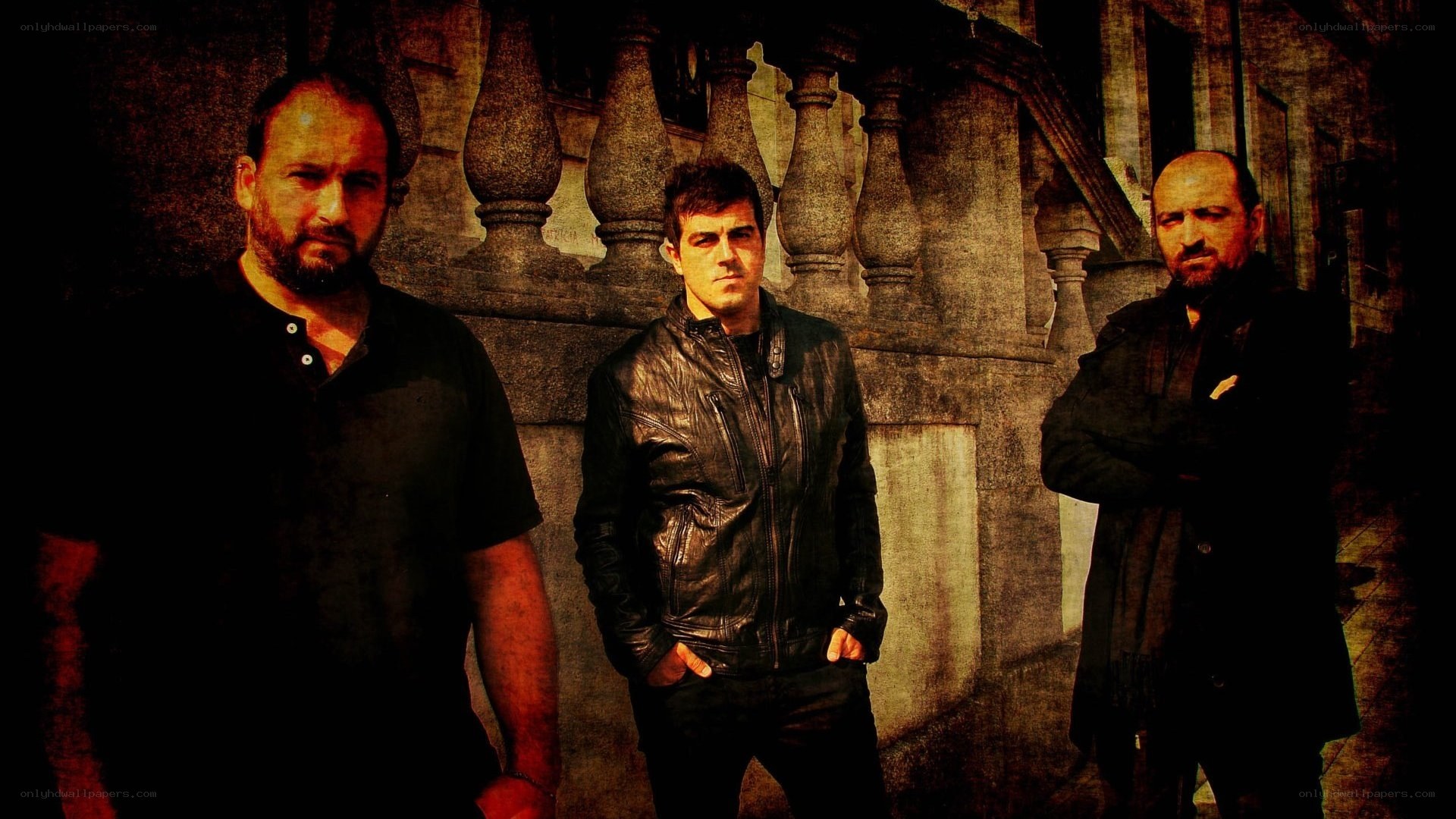 three men standing in front of stone railing