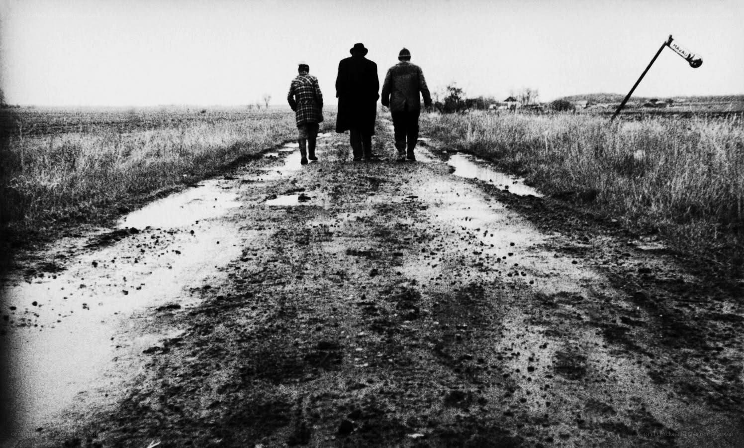 Three men walking on a muddy road