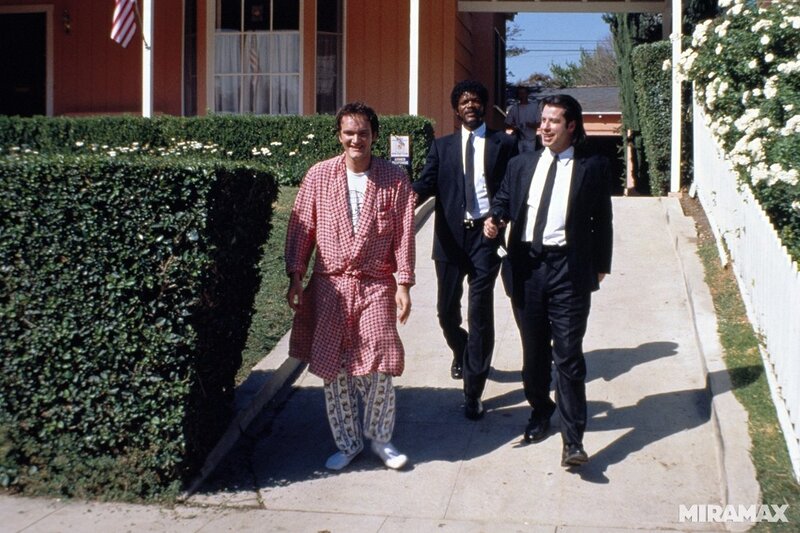Three men walking on a sidewalk