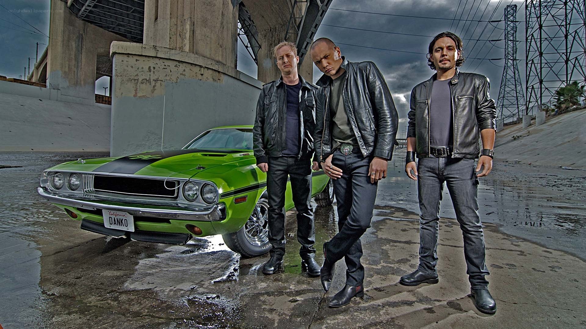 Three men with a green muscle car