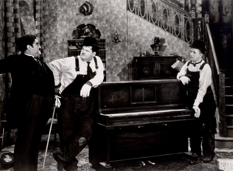 Three men with a piano