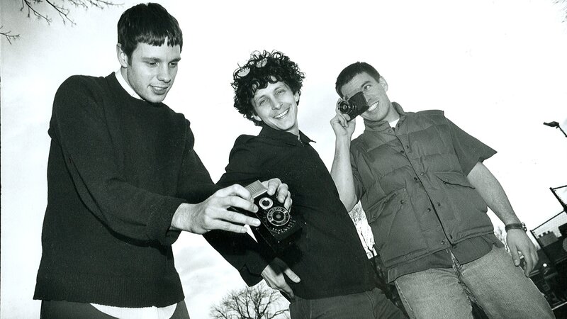 Three men with cameras outdoors