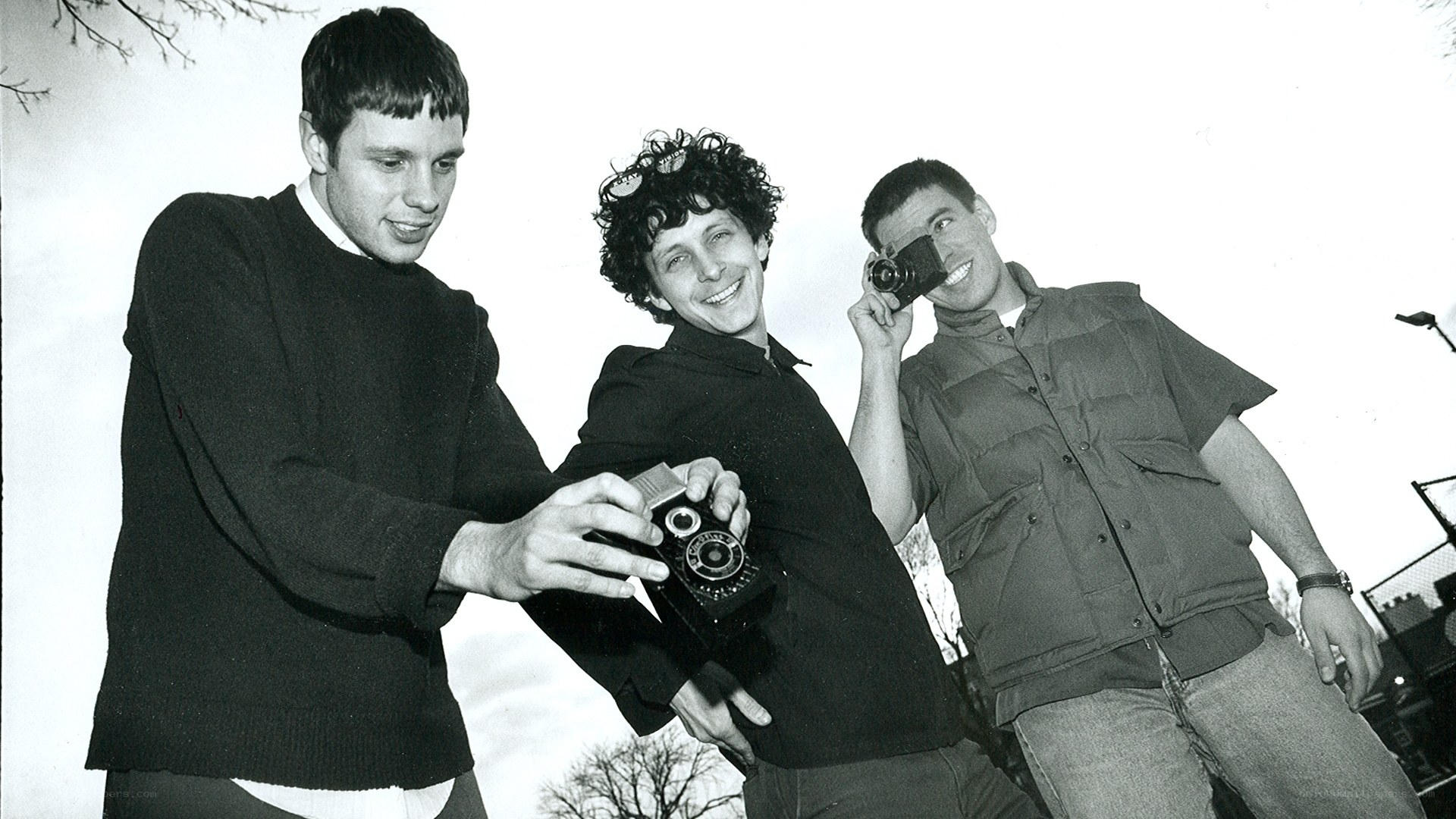Three men with cameras outdoors