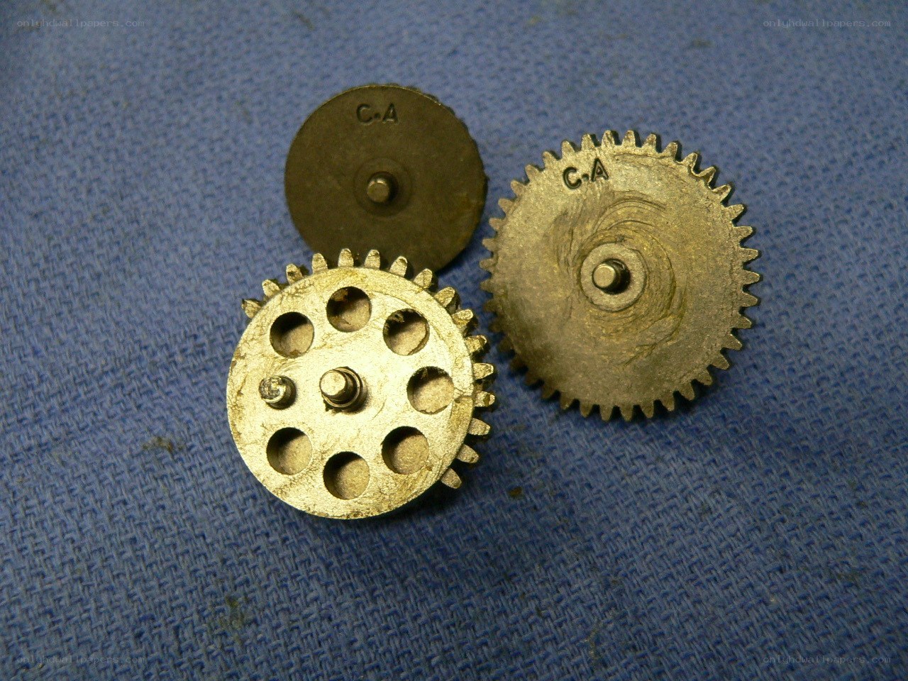 three metal gears on blue cloth