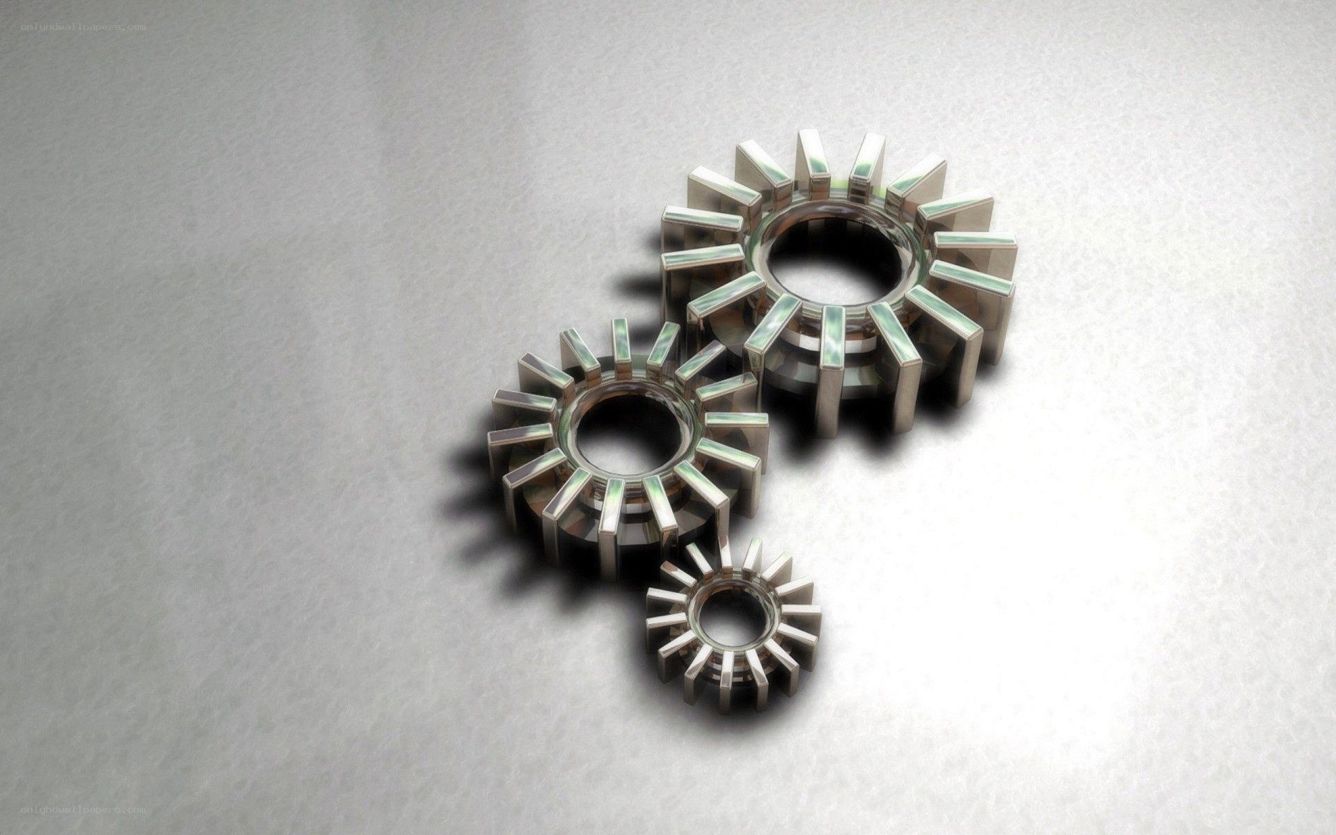 three metal gears on gray surface
