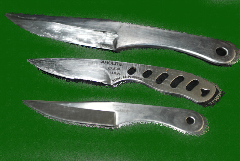 Three metal knives on green