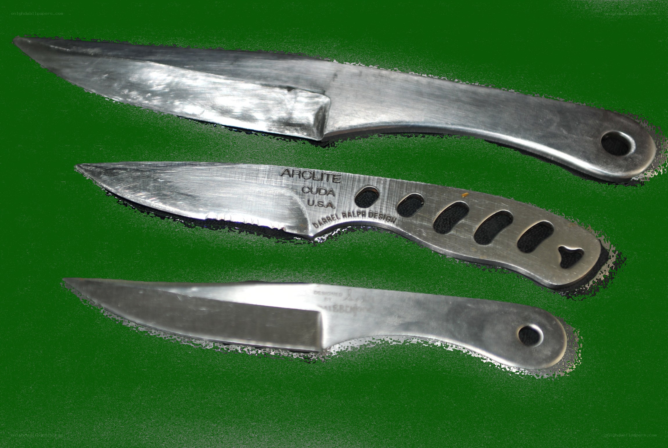 Three metal knives on green