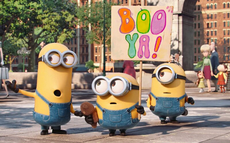 Three Minions Holding Sign