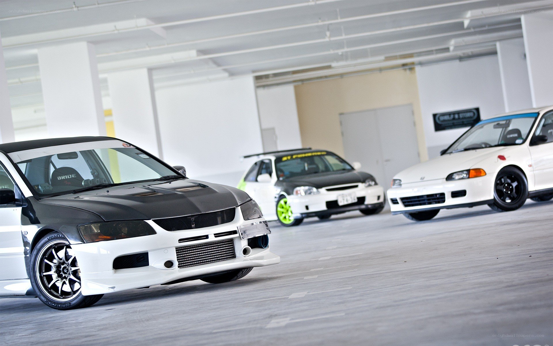 three modified cars in garage