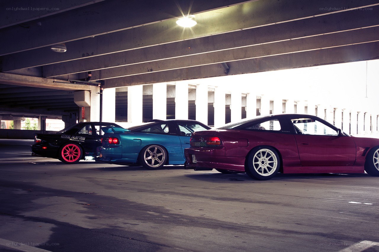 three modified cars under a bridge