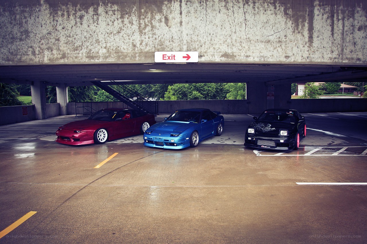 Three modified cars under a bridge