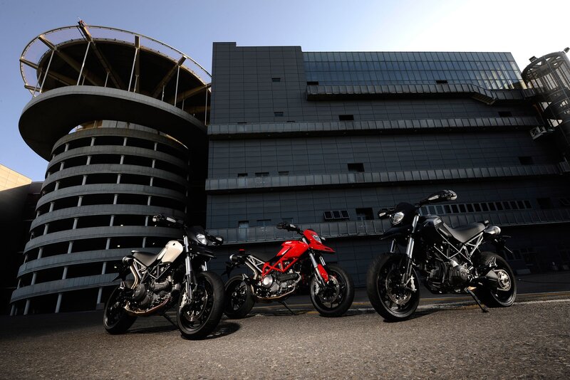Three motorcycles in front of modern building