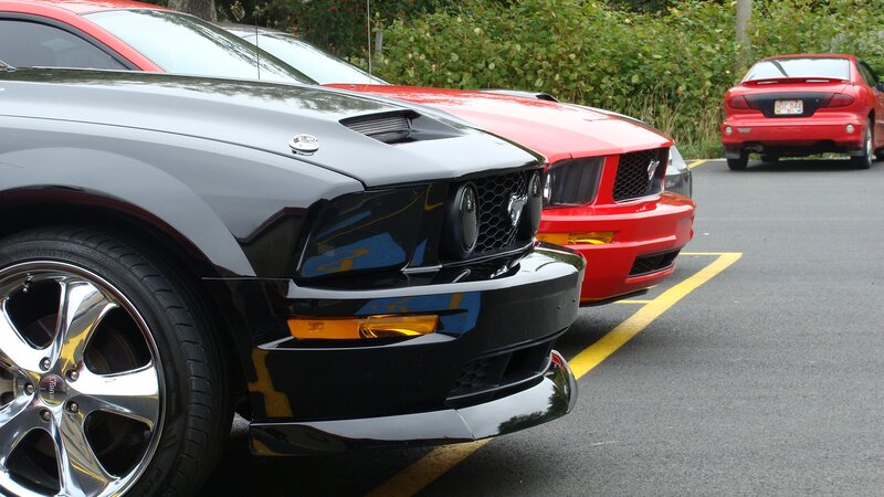 three mustang cars in parking lot