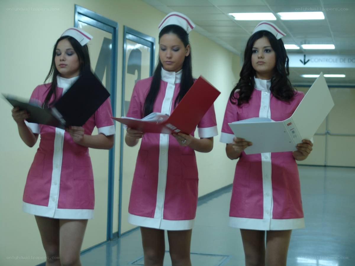 Three nurses in a hospital corridor