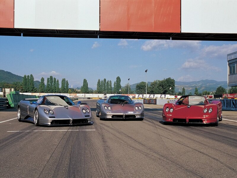 Three Pagani sports cars on a racetrack