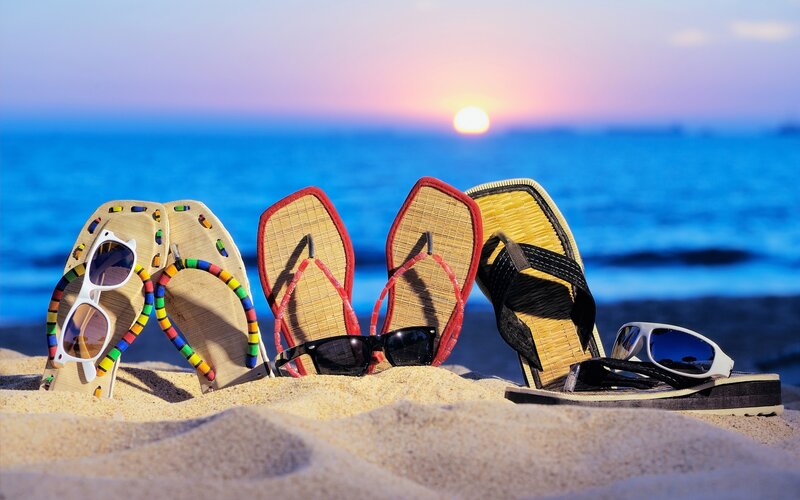 Three Pairs of Sandals on Beach
