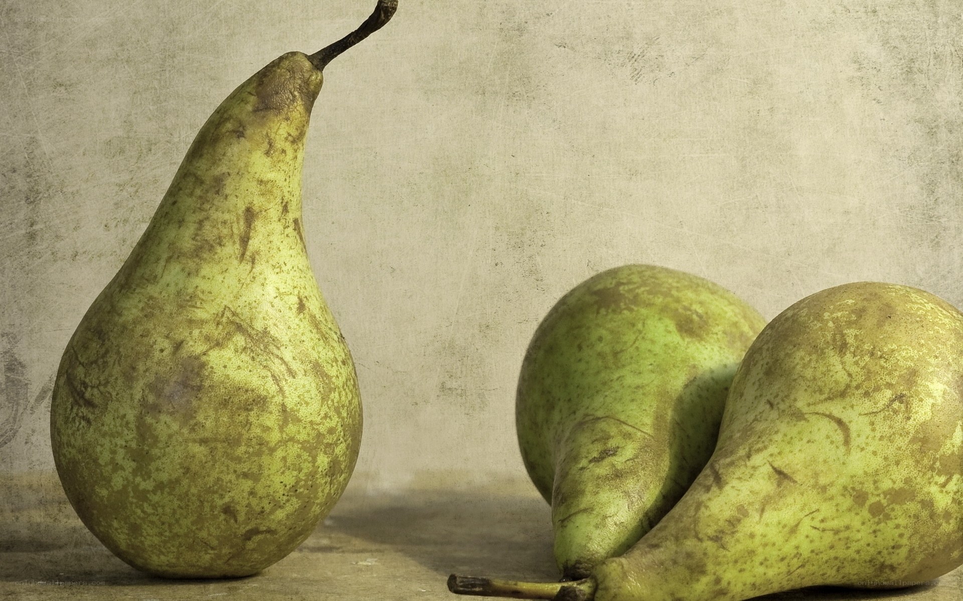 Three pears on a textured surface