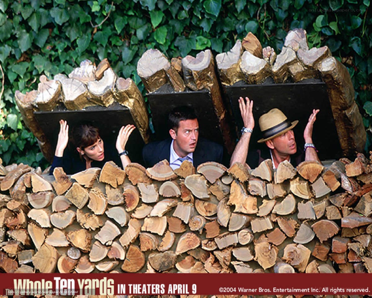 Three people hiding behind woodpile