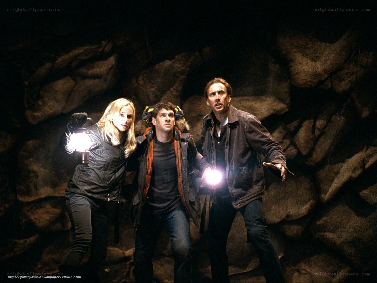 Three people in a cave