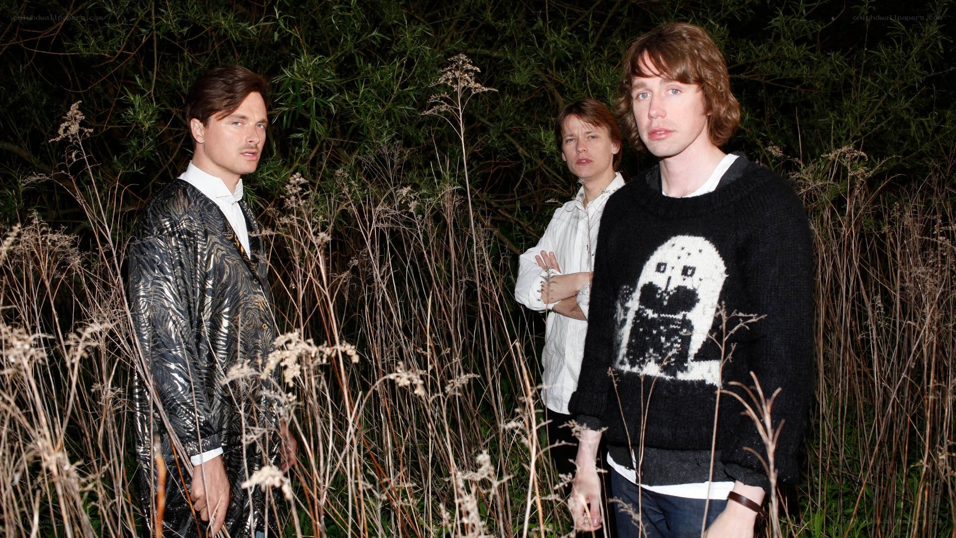three people in a field at night
